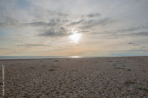 Sun sets on stony beach in beautiful light