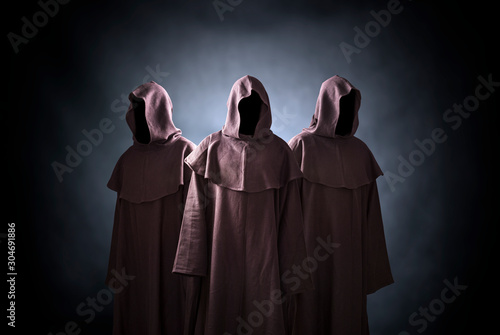 Foto Group of three scary figures in hooded cloaks