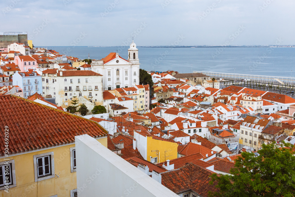 Lisbon, Portugal - May, 23rd, 2018 : Alfama district overview and Saint Stephen Church (Santo Estevao) as seen from the Miradouro de Santa Luzia viewpoint.