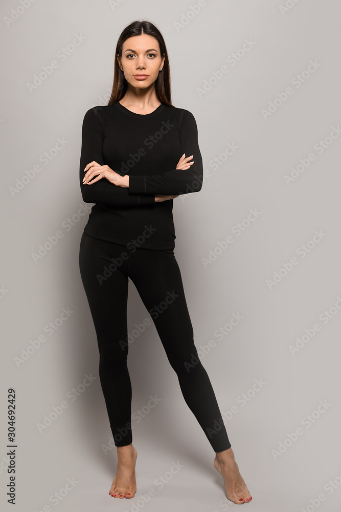 Woman wearing thermal underwear on grey background Woman wearing thermal underwear on grey background