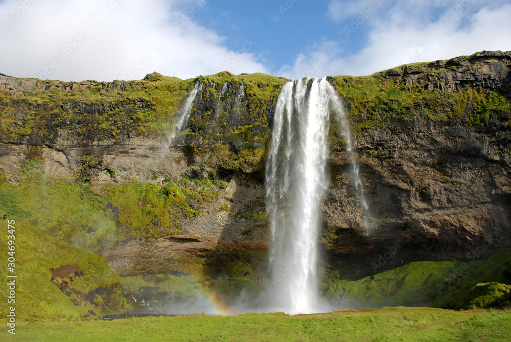 Seljalandsfoss Waterfall in Iceland. A famous waterfall with a path to walk behind the falls. Seljalandsfoss Waterfall in Iceland. A famous waterfall with a path to walk behind the falls.