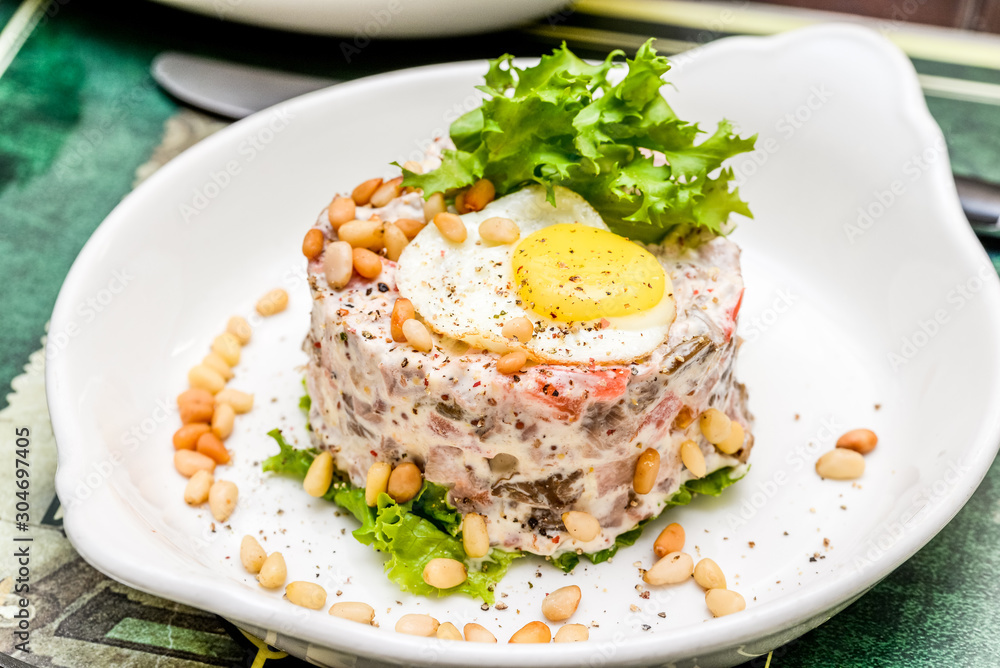 Egg salad with pine nuts on a white plate Egg salad with pine nuts on a white plate