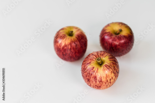 Fresh red yellow striped apples with water droplets on a white glossy kitchen table. Tasty bright juicy fruits. Healthy eating Isolated object 