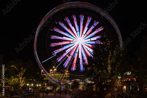 Night scene in an amusement park with a ferris wheel in motion