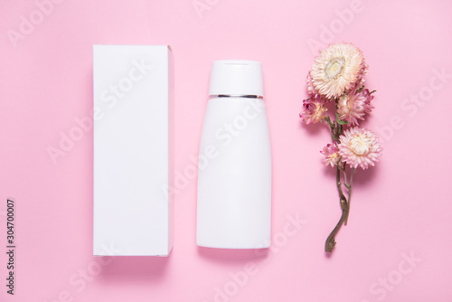 Top view, wthite cream bottle inside of carton cox, case on pink backgrouns, copy space, mock up photo