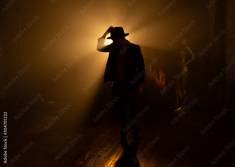 Silhouette of a man in a hat against the light, backlit guitar concert, performance with contrast Silhouette of a man in a hat against the light, backlit guitar concert, performance with contrast
