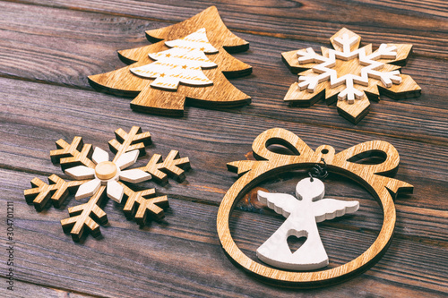 Christmas snowflakes, Christmas tree and angel in a frame on a wooden background. New Year wooden decorations. Toned