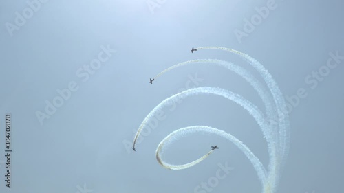Clear blue sky four planes perform aerobatics: take off, make a loop, twist a spiral Leave a pattern in the sky