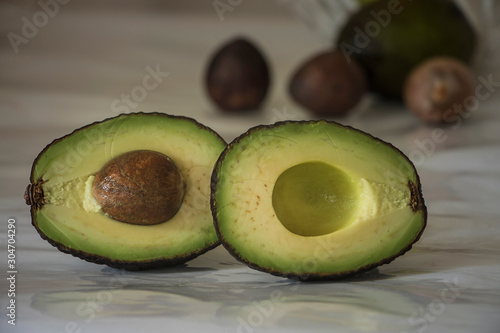 still life with sliced avocado on white background