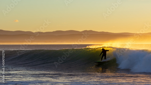 Surfers having fun at sunrise at Super Tubes in Jeffreys Bay, South Africa photo