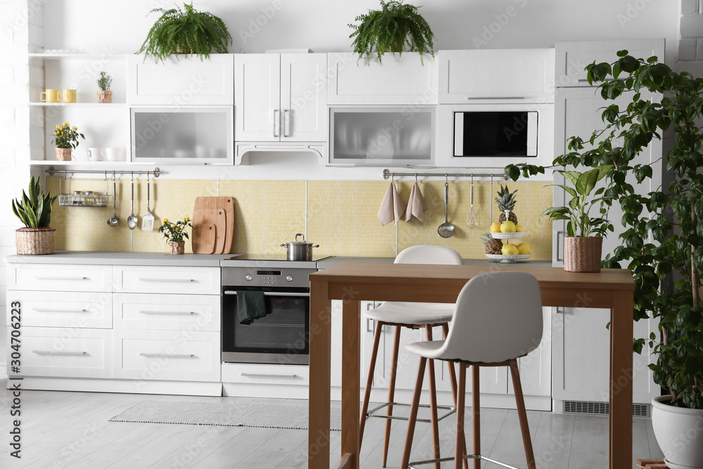 Fototapeta premium Stylish kitchen interior with green plants. Home decoration