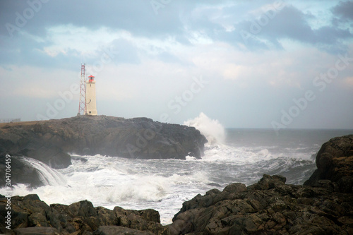 light house on the cliff with the wild sea wave in Iceland