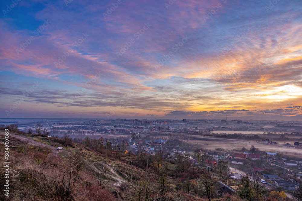 Sunset in the evening over the city in the fog