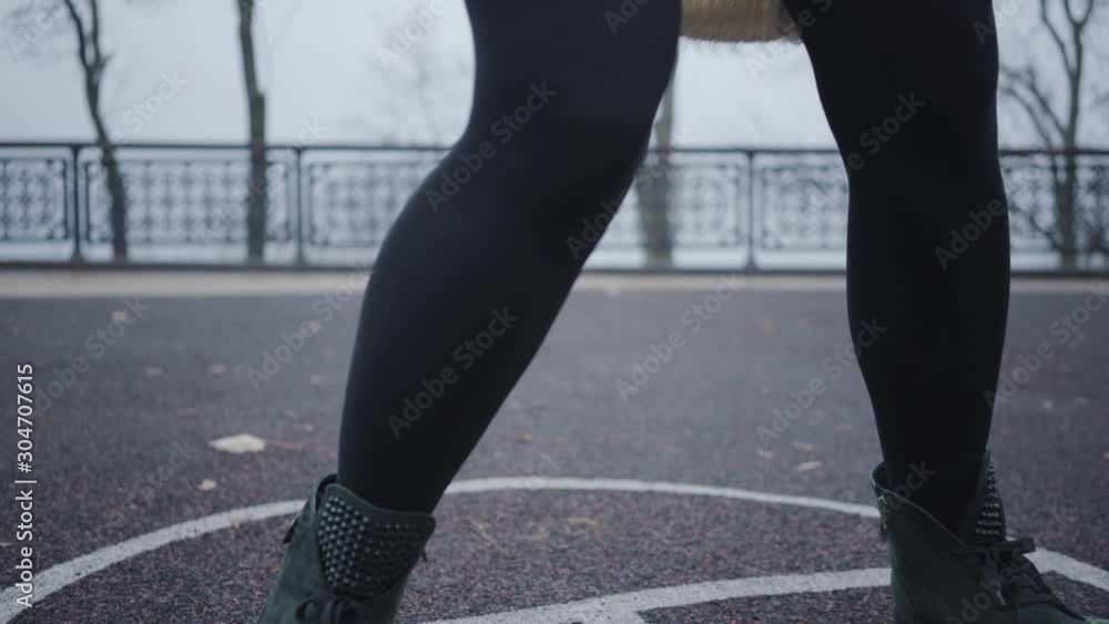 Close-up of female legs jumping on the hopscotch game drawn on the asphalt. Cheerful girl or woman having fun outdoors. Close-up of female legs jumping on the hopscotch game drawn on the asphalt. Cheerful girl or woman having fun outdoors.