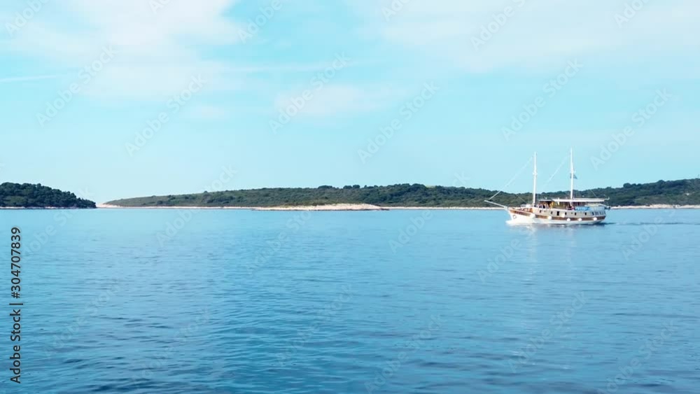 View on passing by sailboat with the coastline in the background View on passing by sailboat with the coastline in the background