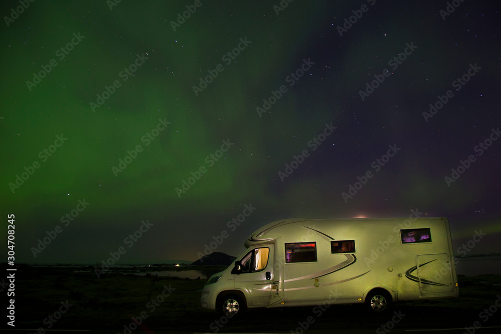 Colorful Northern lights with green blue stripes over the iceland