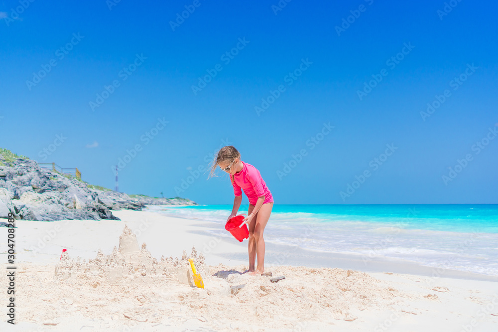 Little adorable girl playing on beach with ball