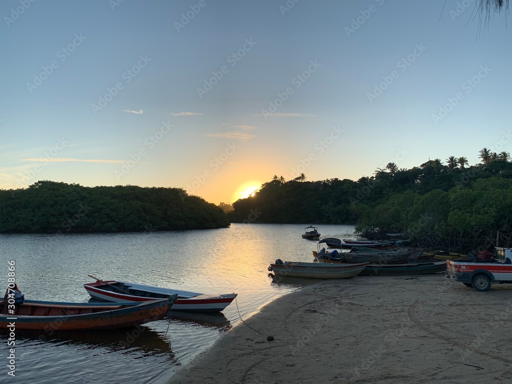Wooden boats over calm river at sunset