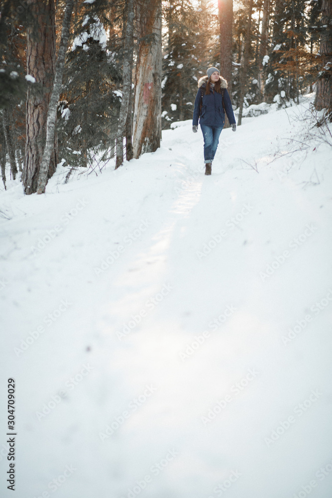 Beautiful smiling young woman walking in winter forest. Winter concept