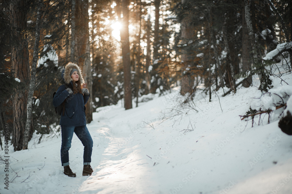 Beautiful smiling young woman walking in winter forest. Winter concept