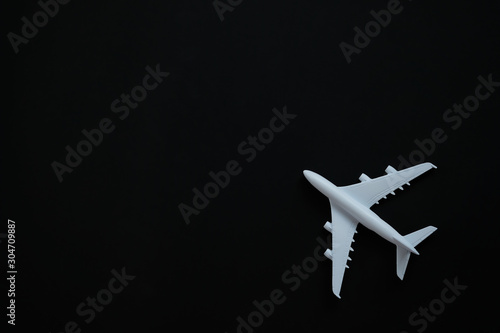 Miniature toy airplane white on black background.