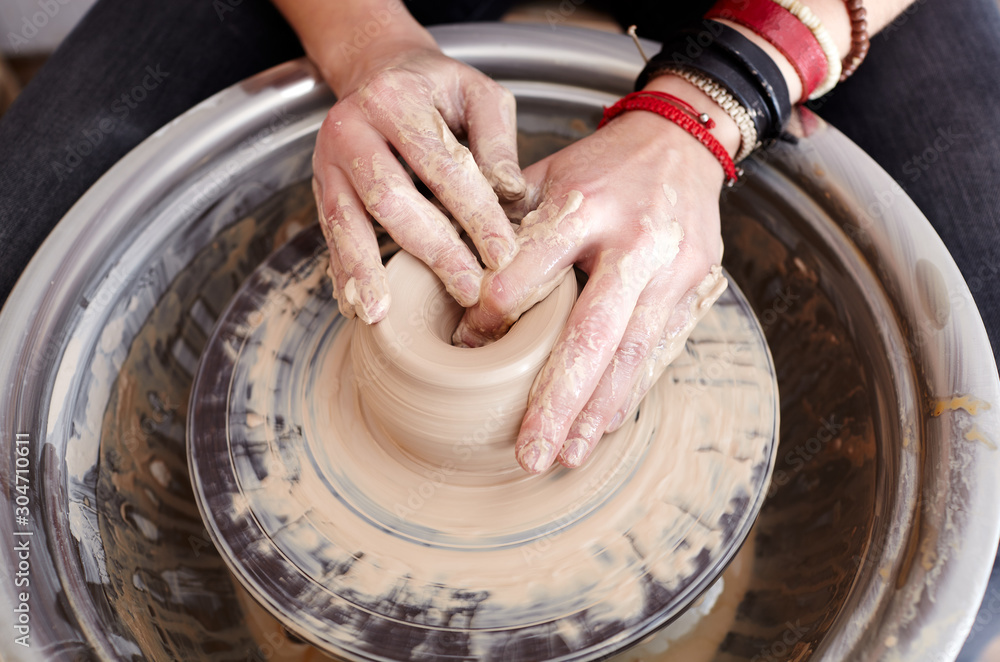 Woman's hands molding clay. Potter making ceramic pot in pottery workshop Woman's hands molding clay. Potter making ceramic pot in pottery workshop