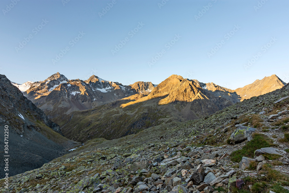 Sunrise in the Stubai Alps (Tirol, Austria). Landscape with rocky mountains and some snow. Copy space.