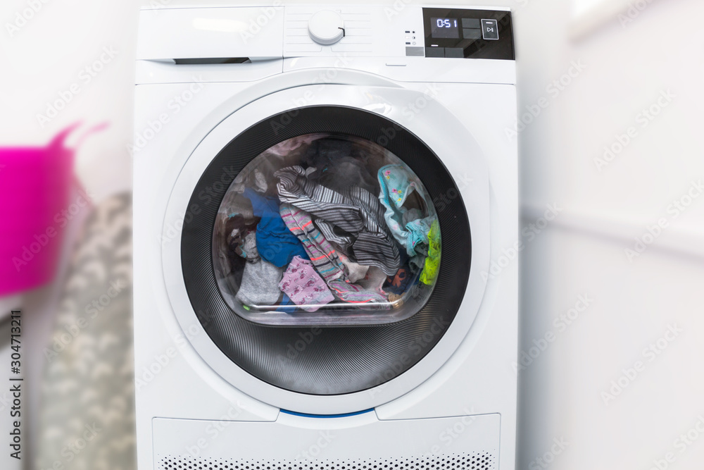 Electric dryer with clothes inside in the laundry room Electric dryer with clothes inside in the laundry room
