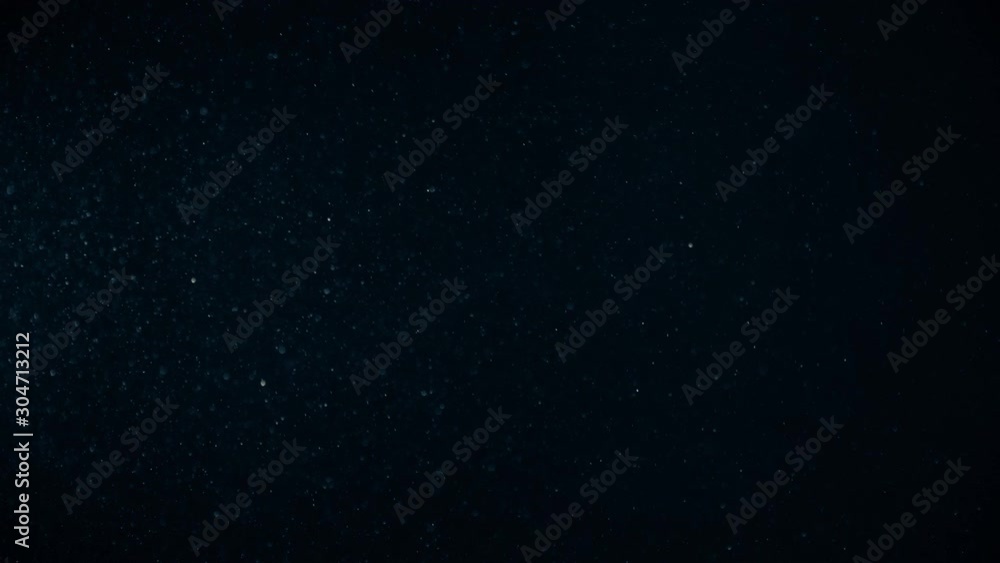 Natural Organic Dust Particles Floating On Black Background. Dynamic Dust Particles Randomly Float In Space With Fast And Slow Motion. Shimmering Glittering White Particles With Bokeh In The Air. Natural Organic Dust Particles Floating On Black Background. Dynamic Dust Particles Randomly Float In Space With Fast And Slow Motion. Shimmering Glittering White Particles With Bokeh In The Air.