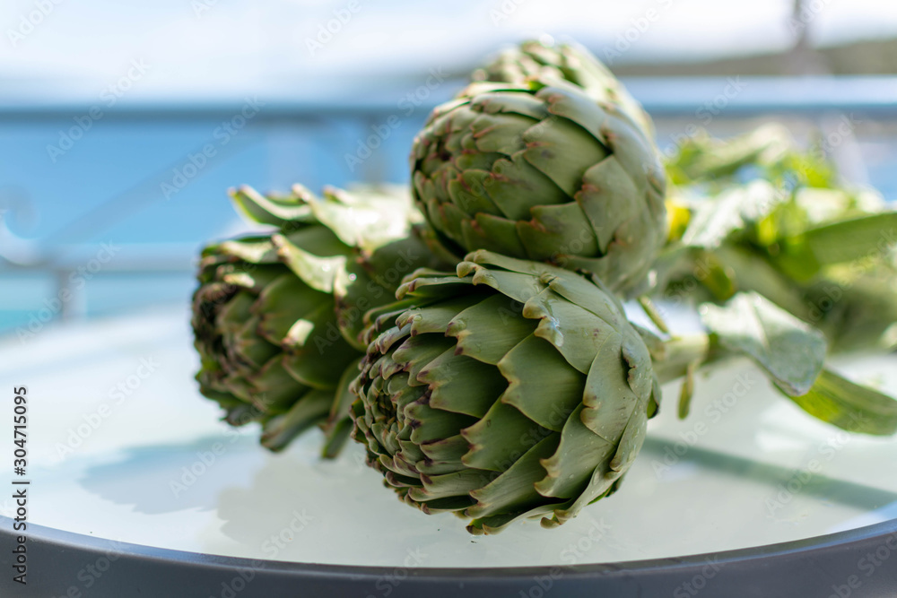 Fototapeta premium Bunch of fresh raw artichokes heads from artichoke plantation in Argolida, Greece ready to cook