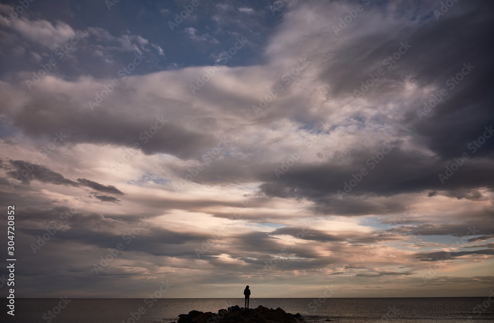A man contemplates the Mediterranean Sea from the rocks of the Plage Baleine in Sète. France