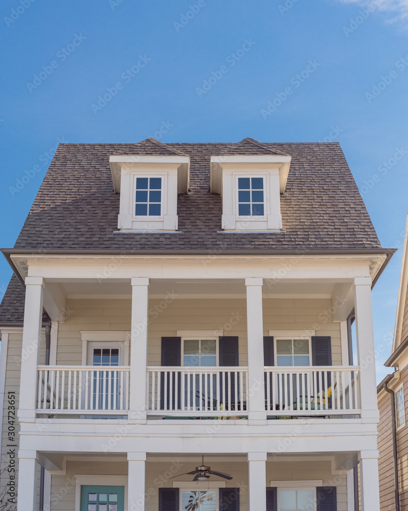 White painted porch with banister and dormer roof of two story houses near Dallas, Texas