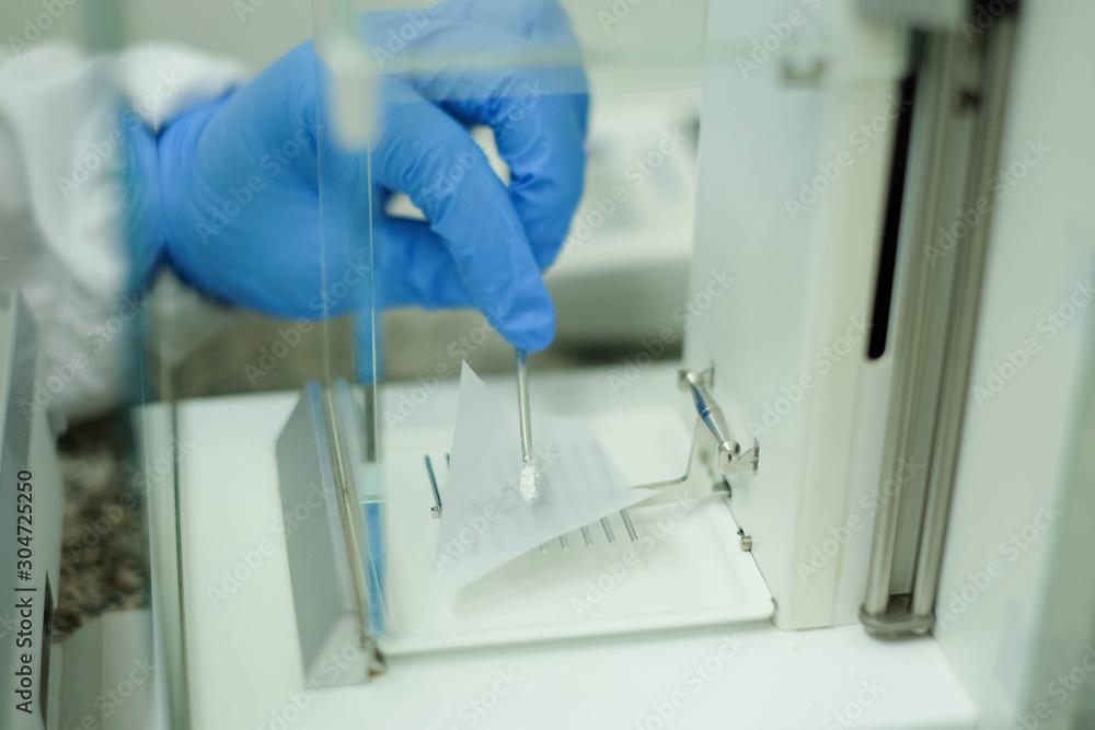 Naklejka premium Weighing sample on the micro balance for sample solution preparation, chemical analysis of pharmaceutical laboratory.