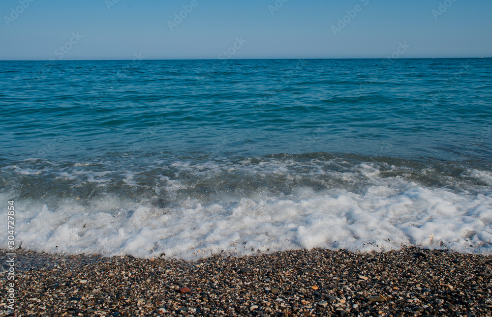 waves breaks when you reach the sand with strength and white foam waves breaks when you reach the sand with strength and white foam