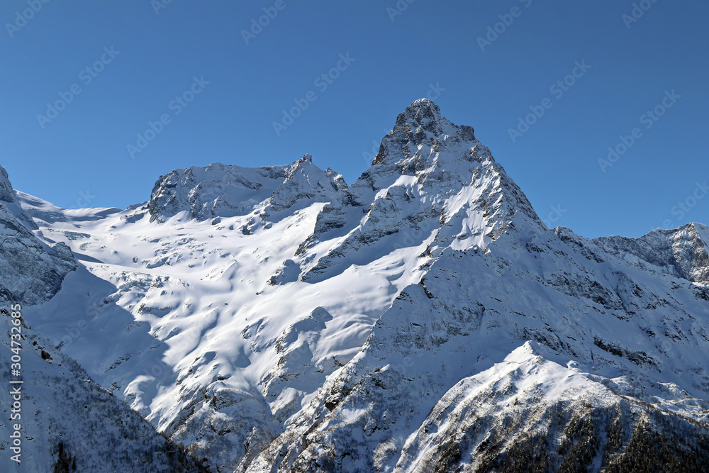 Snowy Mountains peaks in the blue sky Caucasus