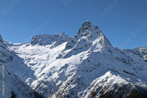 Snowy Mountains peaks in the blue sky Caucasus