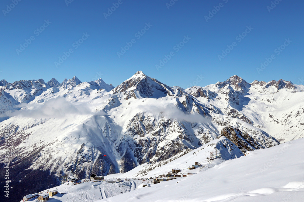 Snowy Mountains peaks in the clouds blue sky Caucasus