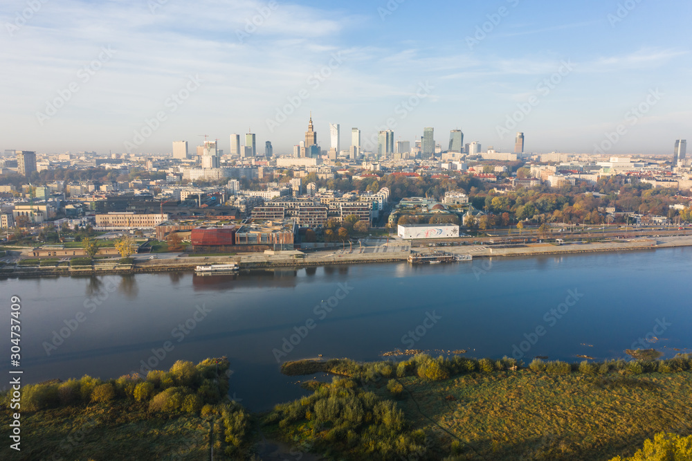 Fototapeta premium Warsaw, Poland. City landscape at sunrise. Aerial view of the river and the city with skyscrapers and buildings in the early morning.