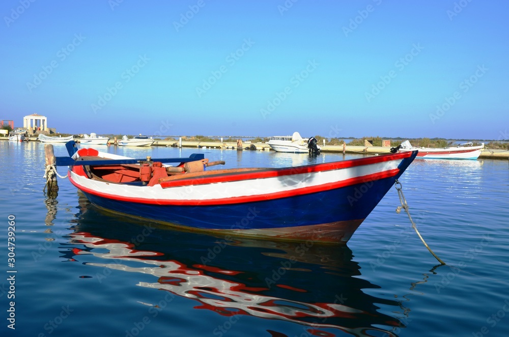 Lefkada, Lefkada Island, Greece. 10/22/2019.  wooden ship blue, white and red color, fishing boat on the water in the port on the pier