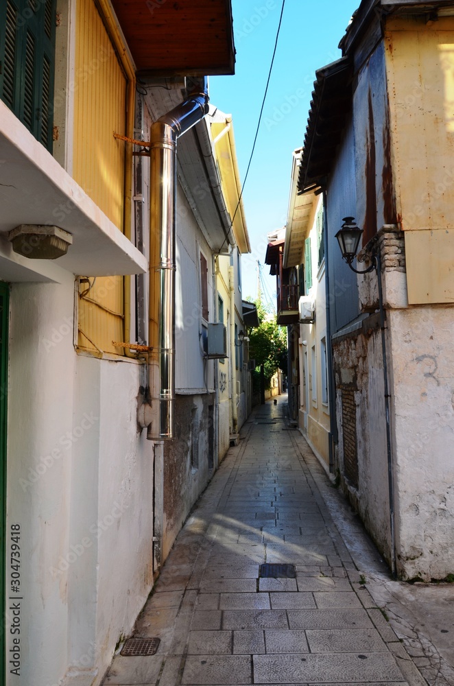 Lefkada, Lefkada Island, Greece. 10/22/2019. narrow streets, old houses with lanterns, balconies, green plants, bright flowers in a European town on the island. cityscape, street without people