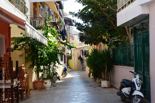 Lefkada  Lefkada Island  Greece. 10 22 2019. narrow streets  old houses  windows  doors  balconies  green plants  motorbike  moped  in a European town on the island. cityscape  street without people