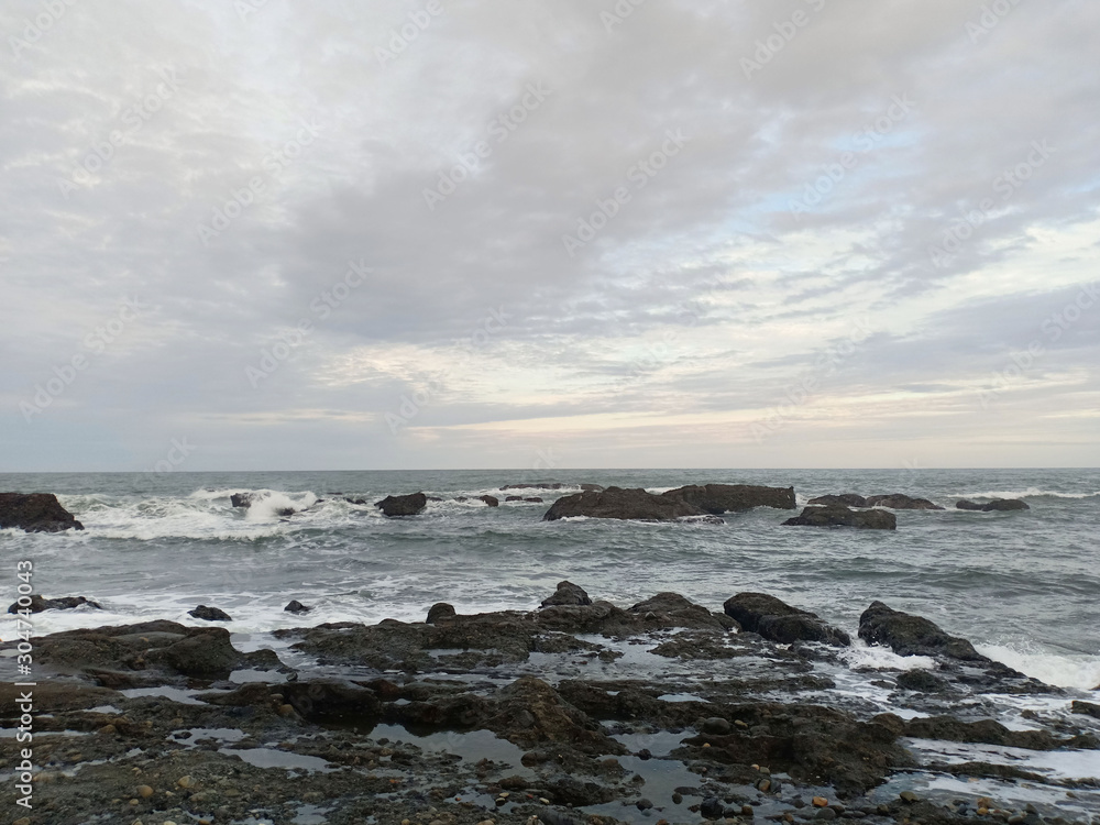The view of the sea is rocky and the evening sky.