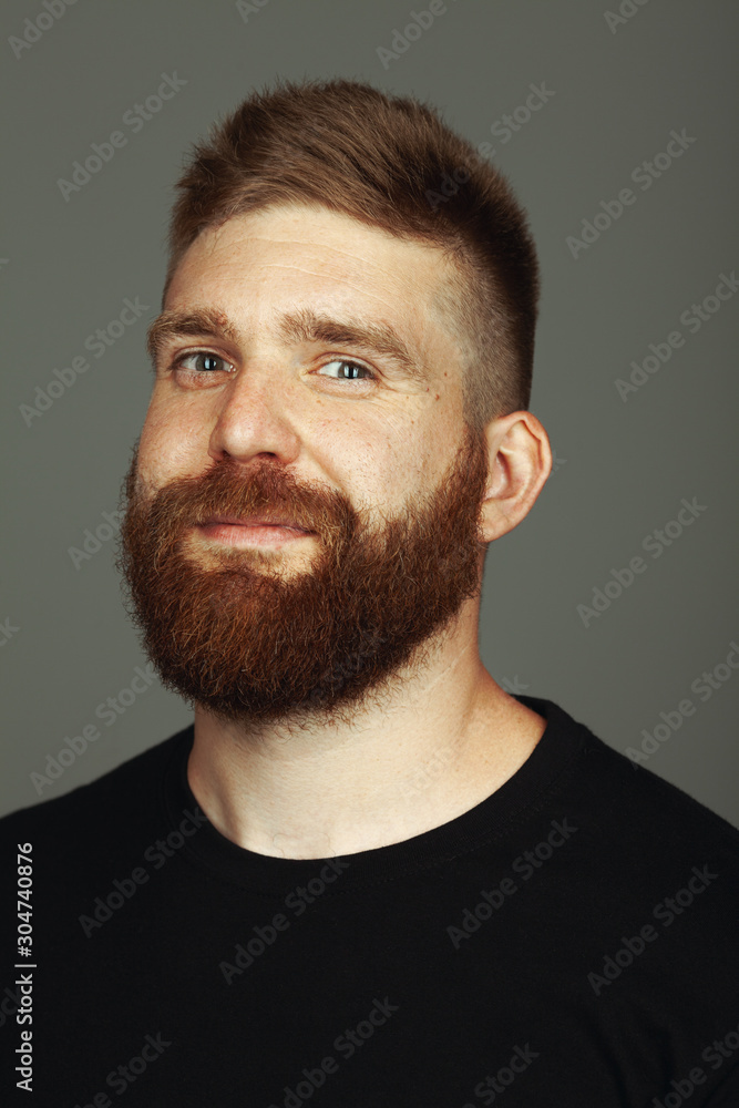 Fabulous at any age. Close up portrait of charismatic muscular 30-year-old man standing over dark gray background. Perfect haircut. Rocker, biker, hipster style. Studio shot Fabulous at any age. Close up portrait of charismatic muscular 30-year-old man standing over dark gray background. Perfect haircut. Rocker, biker, hipster style. Studio shot