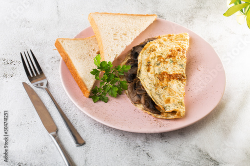 Omelet with mushrooms and sourdough toast isolated on white marble background. Homemade food. Tasty breakfast. Selective focus. Hotizontal photo.