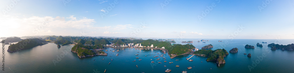 Aerial unique view Vietnam Cat Ba bay with floating fishing boats on sea, cloudscape tropical weather inspirational sunset, epic city skyline and skyscraper, scenic green mountain.