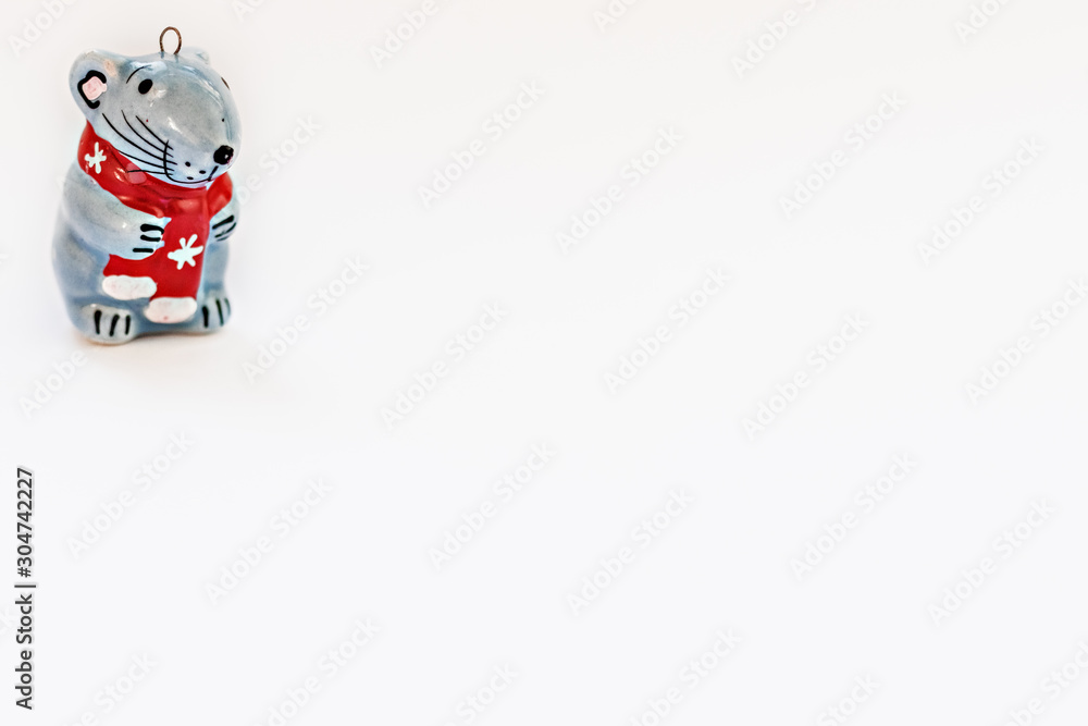 Obraz premium Ceramic figurine of a Christmas rat on a white background. Symbol of the new year 2020.