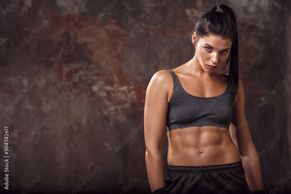 Fototapeta premium Boxing. Woman boxer isolated on wall looking camera curious