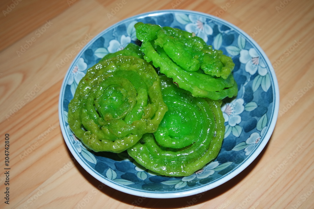 Crispy sweet Asian dessert green Jalebi cooked and served in ceramic plate. Crispy sweet Asian dessert green Jalebi cooked and served in ceramic plate.