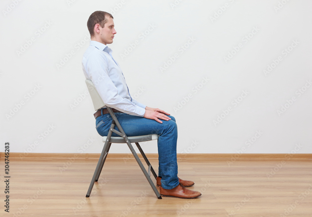 caucasian man sitting on the  chair in correct  posture - obrazy, fototapety, plakaty 
