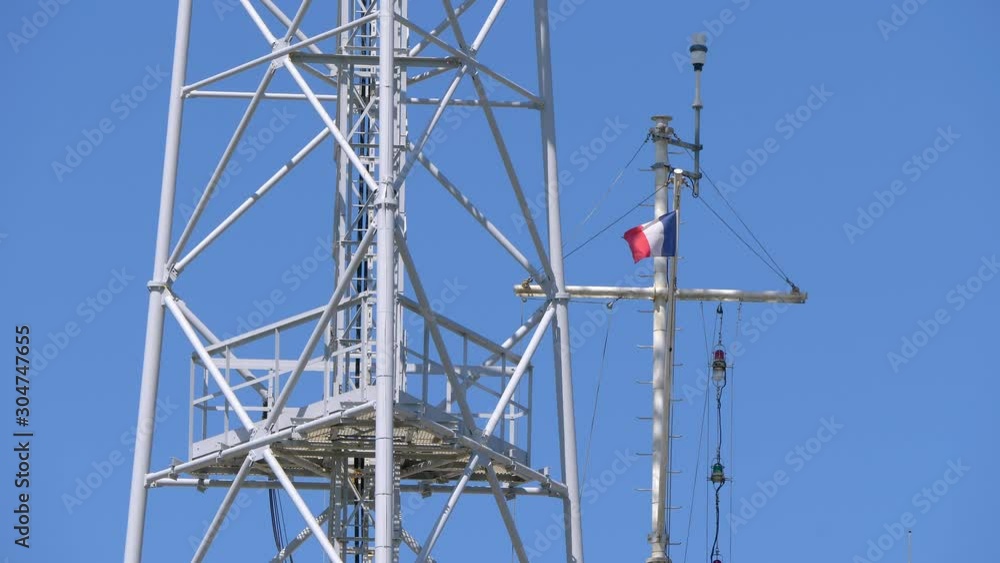 French flag fluttering in the wind in a metal tower